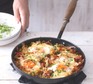 Breakfast hash in a pan with eggs