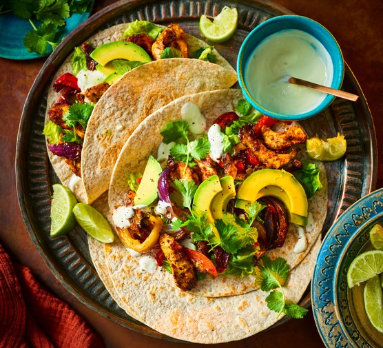 Chicken fajitas with lots of toppings on a plate