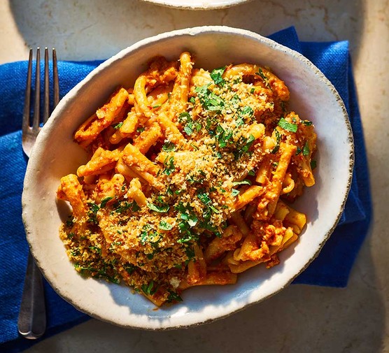 A bowl of anchovy red pesto pasta with crispy garlic pangrattato