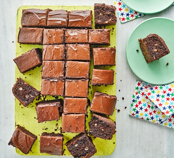 Chocolate chip traybake cake with frosting cut into squares