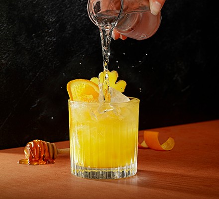 Glass of orange cocktail with ice