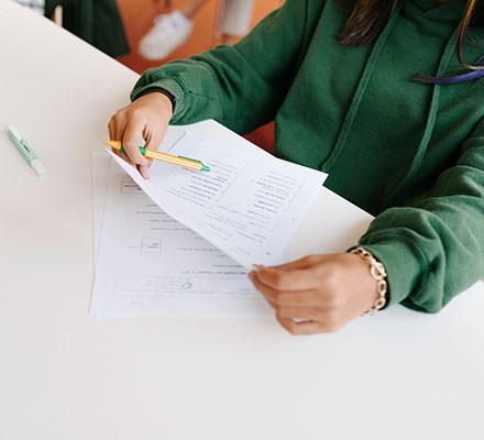 Someone with a paper and pencil taking an exam