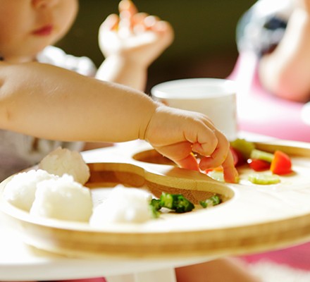 A young child in a high chair eating