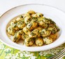 Gnocchi with herb sauce served on a white plate
