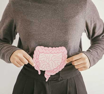 Woman holding a drawing of the intestines over her stomach