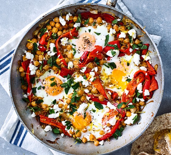 Chickpea, red pepper, egg & feta hash Chickpea, red pepper, egg & feta hash served in a large silver pan resting on top of a tea towel