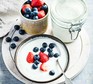 Slow cooker bio yogurt in a jar and a bowl served with berries