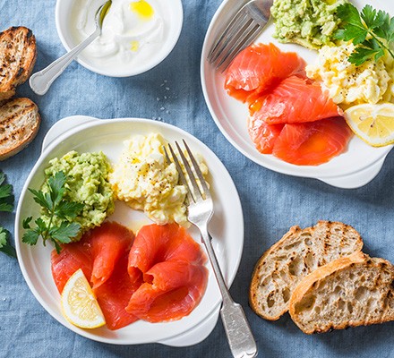 White bowls with avocado, smoked salmon and yogurt