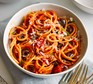 A bowl of spaghetti, coated in nduja and tomato sauce