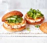 Prawn & salmon burgers with spicy mayo Two prawn & salmon burgers with green salad