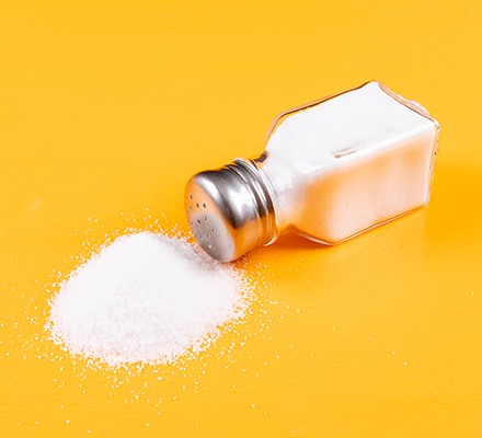 Salt shaker fallen over with salt pouring out