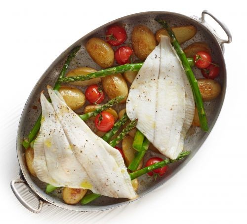 Two plaice fillets with potatoes and vegetables in an oval dish