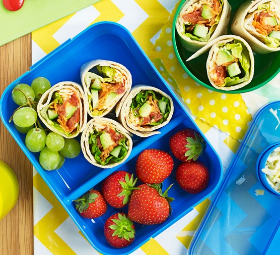 Wraps in a lunchbox with strawberries and grapes