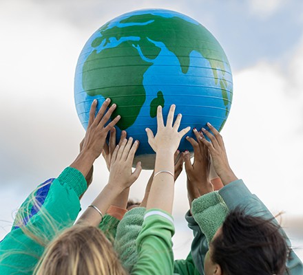 Group of teenagers holding up the world