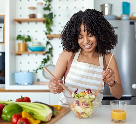 Woman making a healthy salad in her kitchen