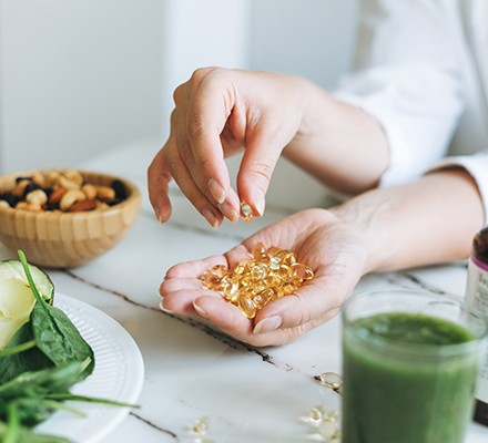 Woman holding vitamin capsules in her hand